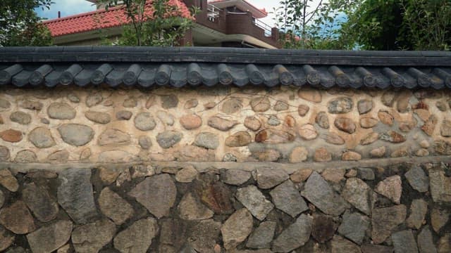 Traditional stone wall in residential area under a blue sky