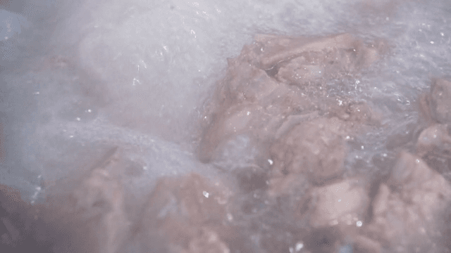 Pork backbones boiling in a large pot