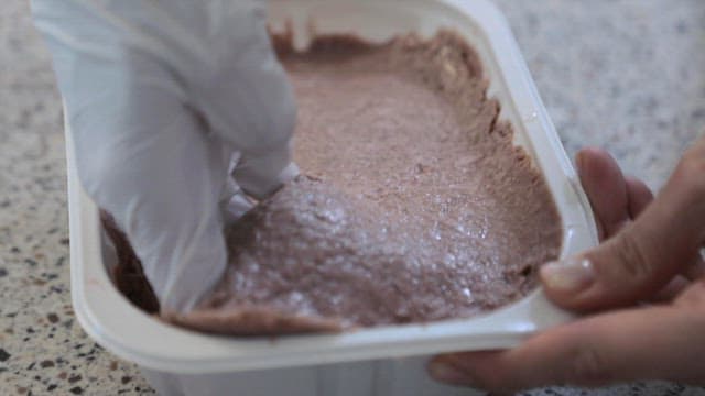 Mixing beef with vegetables in a plastic container