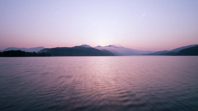 Sunrise over a tranquil lake and mountains