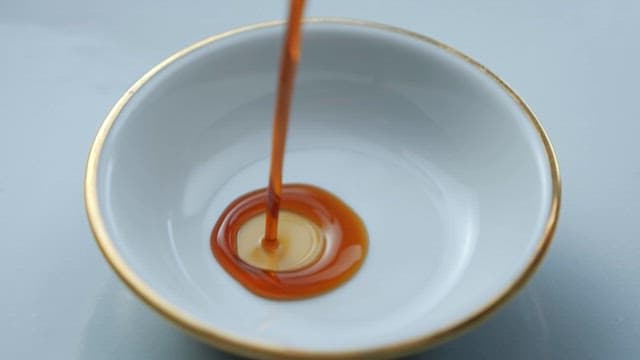 Brown Soy Sauce Poured into a White Small Dish for Soy Sauce