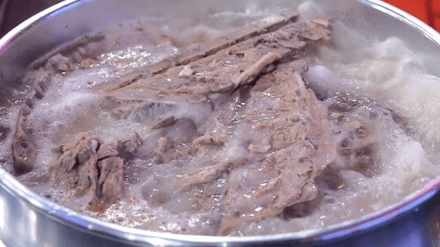 Pork backbones boiling in a large pot
