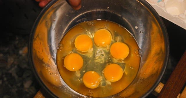 Fresh Eggs Being Beaten in a Metal Bowl