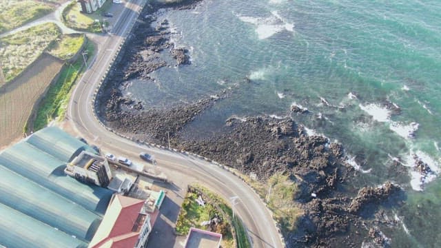 Coastal road with waves crashing on rocks