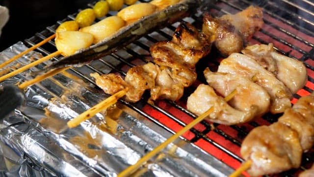 Skewered meat grilling over hot coals