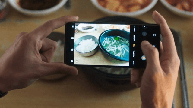 Taking Pictures of a Table Filled with Korean Food with a Phone