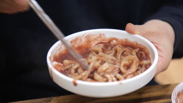 Bowl of red bean noodles being stirred