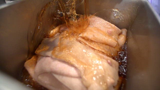 Black secret sauce poured over pork rinds