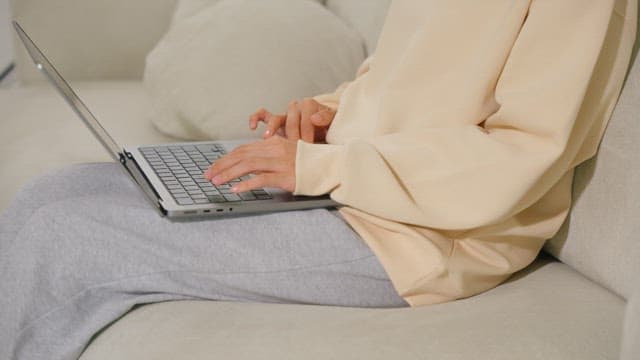 Woman using a laptop on a sofa