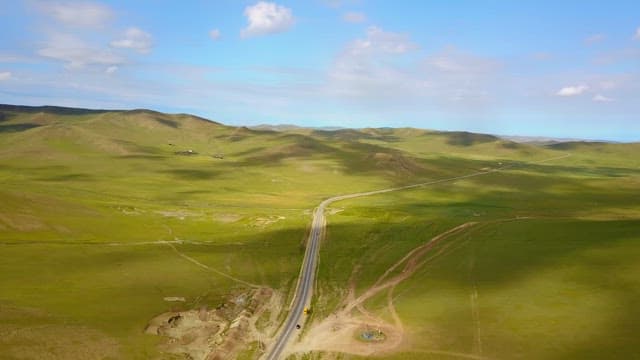 Vast green landscape with a winding road