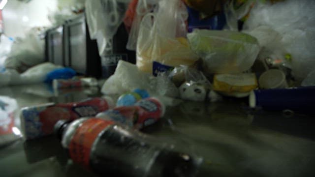 A cluttered indoor space filled with heaps of plastic waste