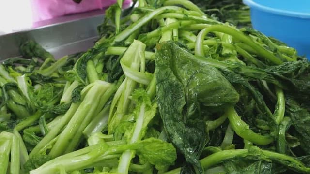 Rubber gloved hands holding and cutting the vegetables