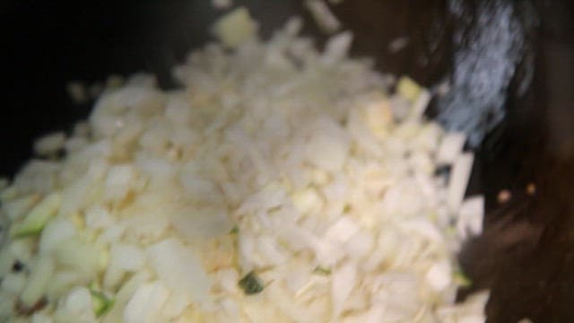 Chopped onions being sautéed in a pan