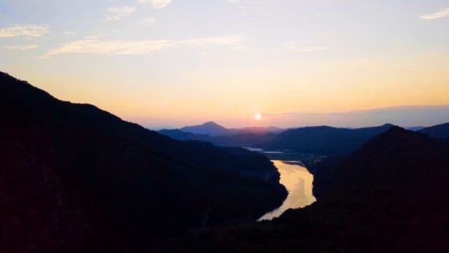 Sunrise Reflected in a Quiet River Beneath the Mountains
