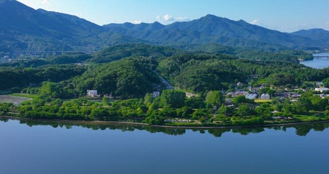 Serene village surrounded by mountains and a river