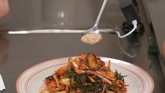 Sprinkle sesame seeds on top of the spicy and sour hijiki seasoned salad