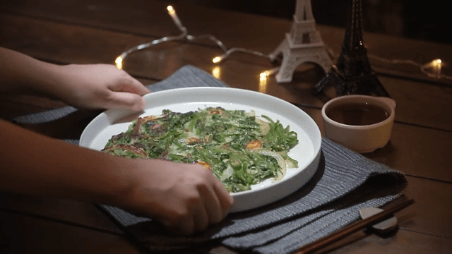 Freshly cooked water parsley served on a cozy, dark table.