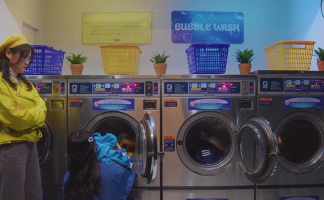 Two girls doing laundry at a laundromat