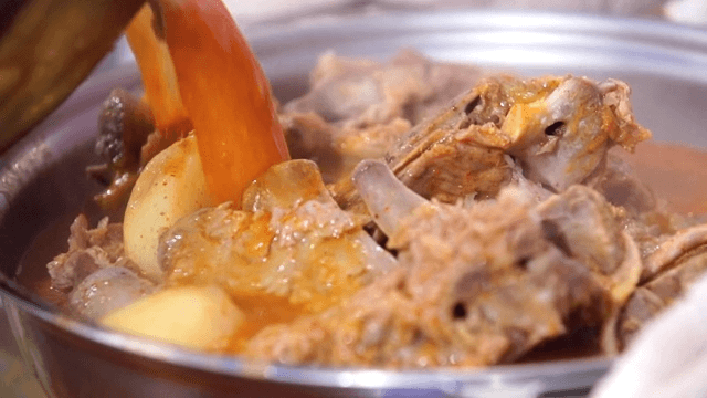 Putting seasoning broth in a pot with pork backbone