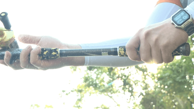 Person fishing with a rod in sunlight