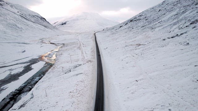 Snowy mountain road with a car