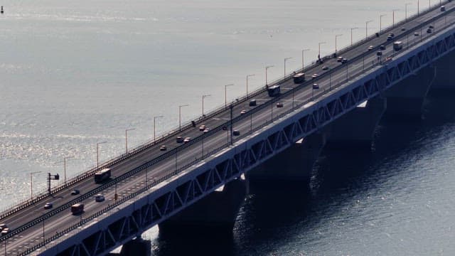 Vehicles crossing a large bridge over water