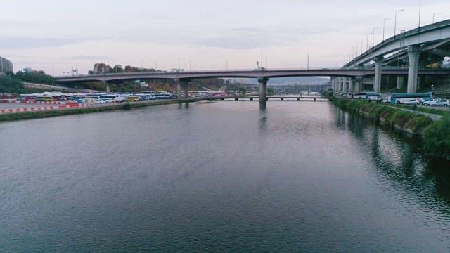 River with bridges and parked buses on the side
