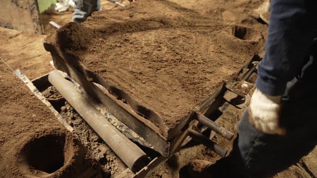 Workers handling sand molds in a factory