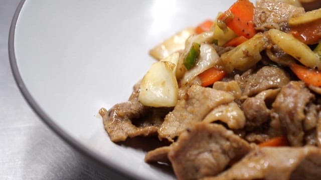 Appetizing pork bulgogi in a white bowl