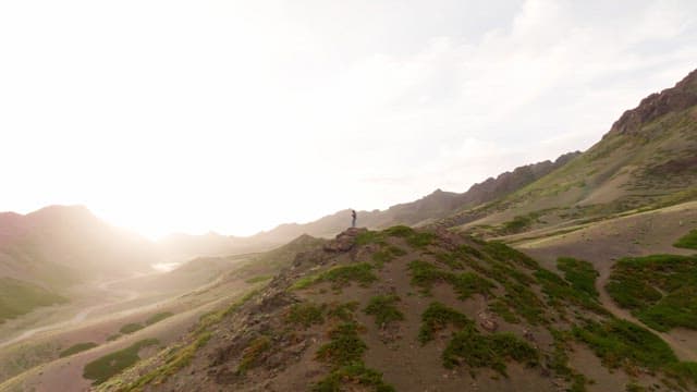Person standing on a mountain in the sunlight
