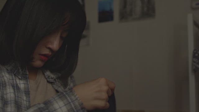 Woman searching for items in her bag in a dark room