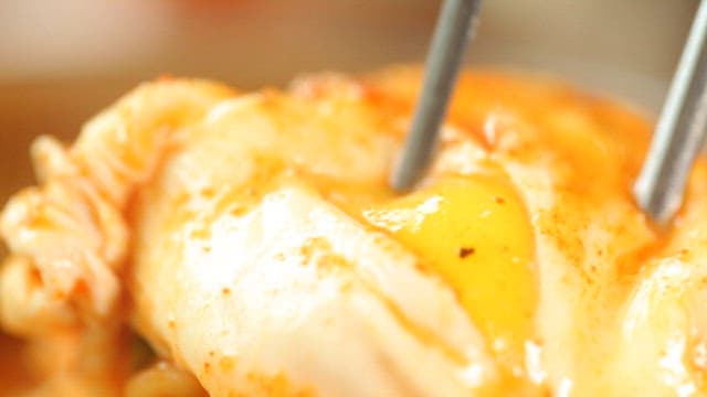 Egg yolk breaking over spicy ramen