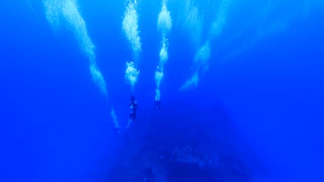 Scuba divers entering the deep sea