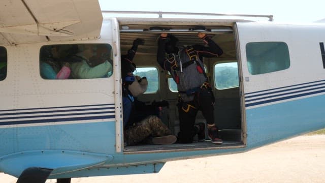 Skydivers preparing for a jump from an airplane