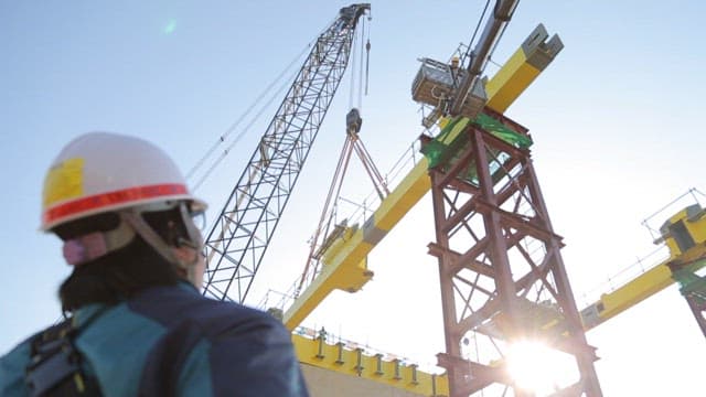 Construction worker supervising crane operations at construction site