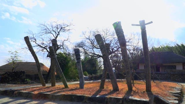 Totem poles at the entrance of a traditional Korean village on a sunny day