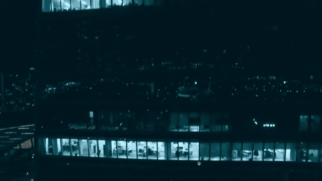 Exterior of a building with a view of the lit offices at night