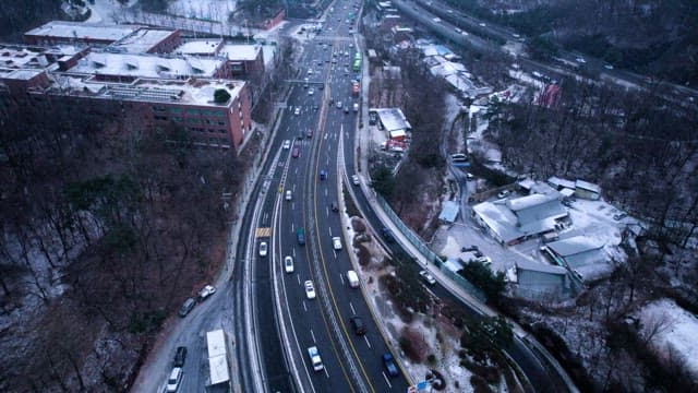 Snowy Cityscape with Traffic on Roads