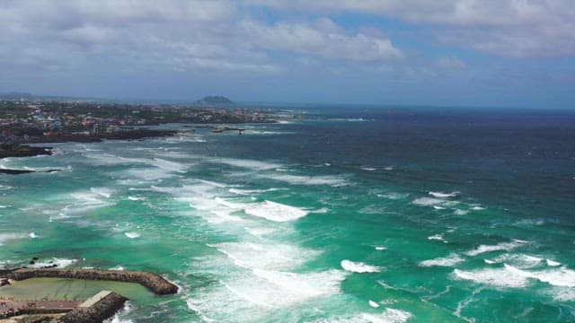 Coastal town with blue sea waves on a cloudy day