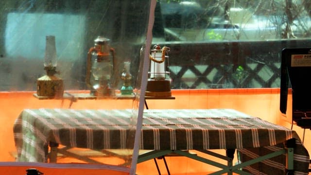 Arranging items on a table inside an outdoor tent