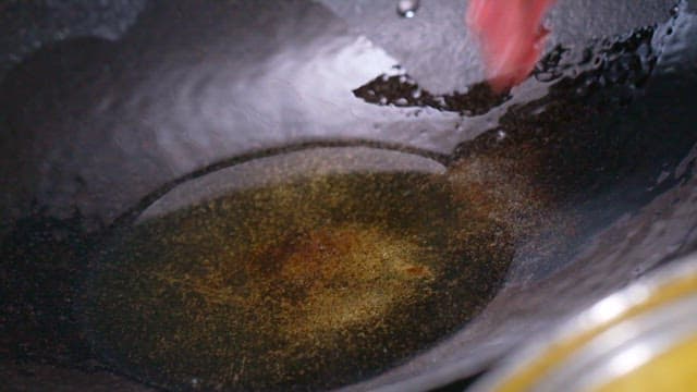 Sliced beef being added to a hot pan