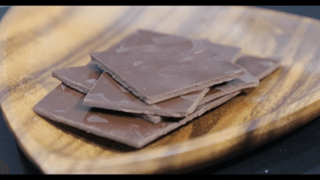 Appetizing chocolate pieces neatly arranged in a wooden bowl
