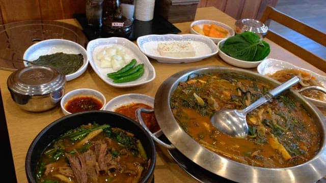 Table in a restaurant with various side dishes and hot pot
