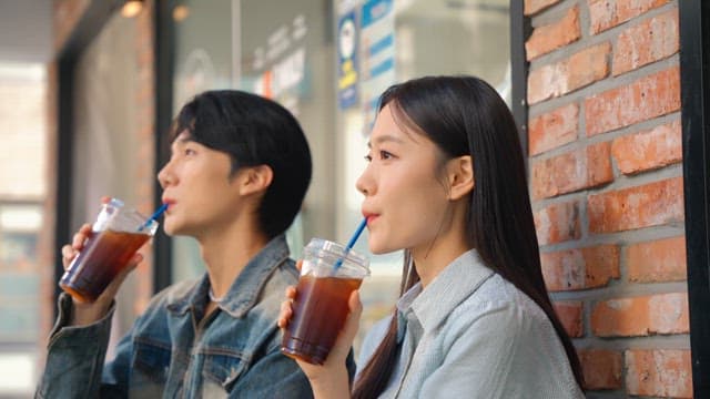 Couple enjoying iced coffee outdoors