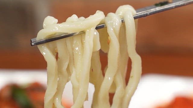 Chopsticks holding freshly cooked kalguksu