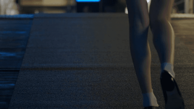 Woman's legs walking down a dark street at night