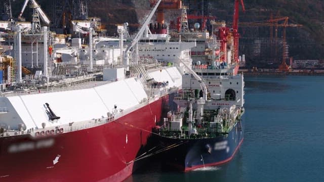 Two large ships docked side by side for cargo transfer