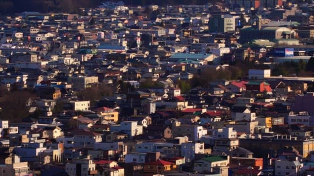 Panoramic view of a city with houses and buildings in the sunset