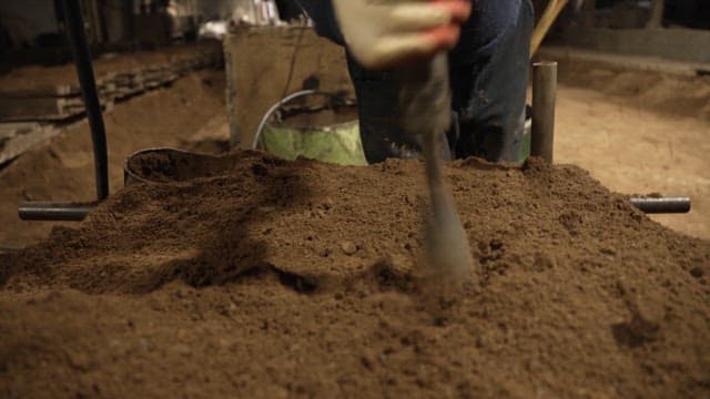 Worker using a tool to shape sand