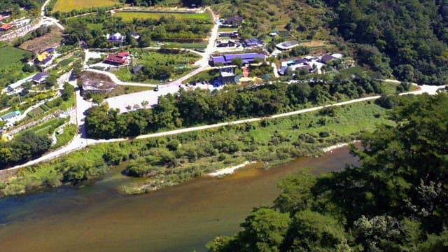 View of rural landscape with river and houses during a sunny day